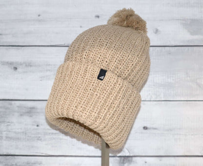 Adult Acrylic Ribbed Cuff Hat with Matching Pom – Cozy & Classic in beige on a display stand.