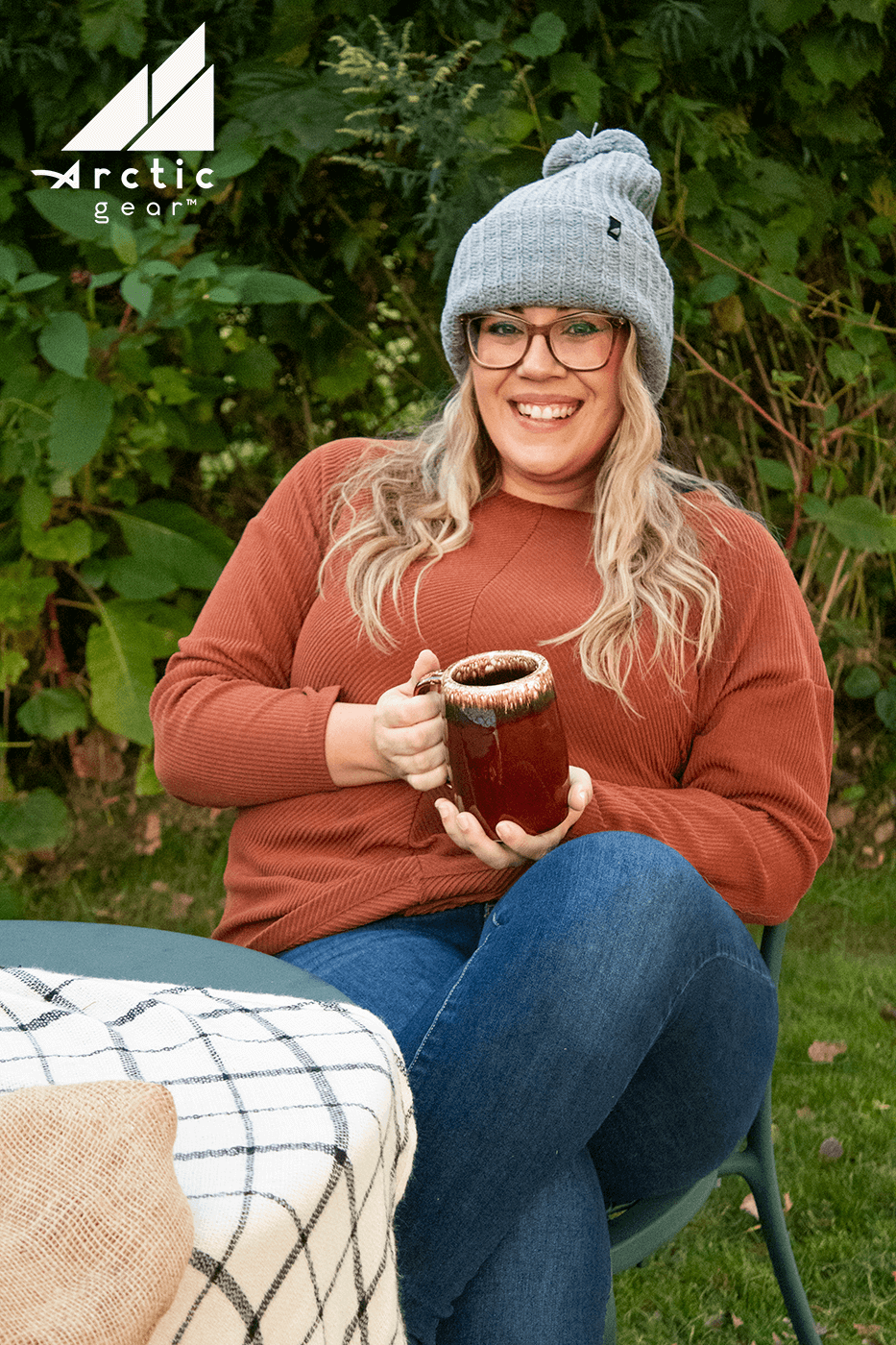 Adult Acrylic Ribbed Cuff Hat with Matching Pom – Cozy & Classic worn by a woman enjoying a warm drink outdoors.