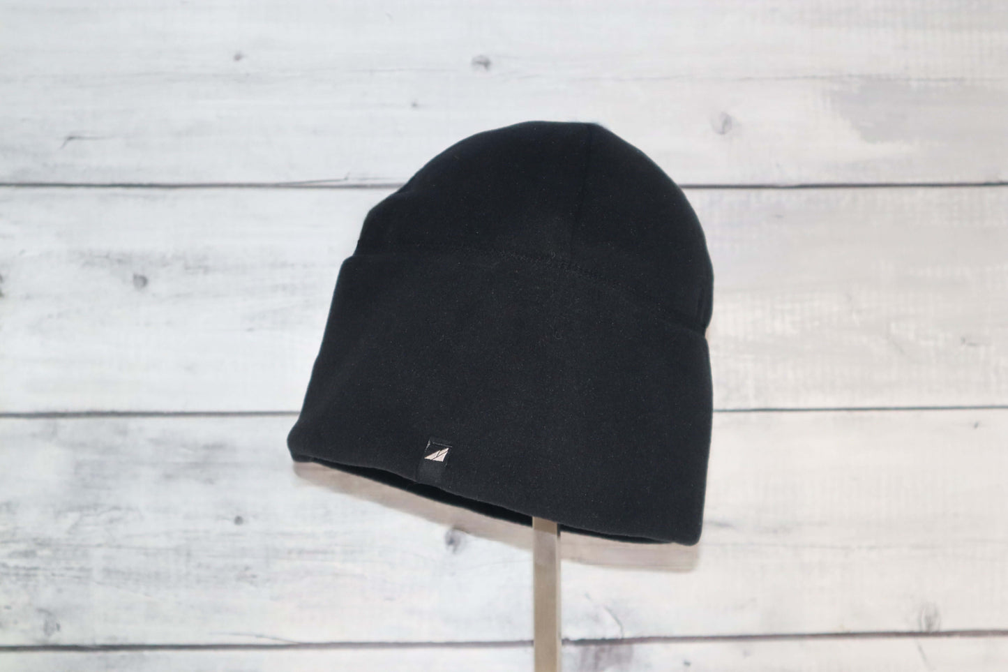 Adult Fleece Cap – Warm Stretch Beanie displayed on a stand with a black fleece material, perfect for cold weather.