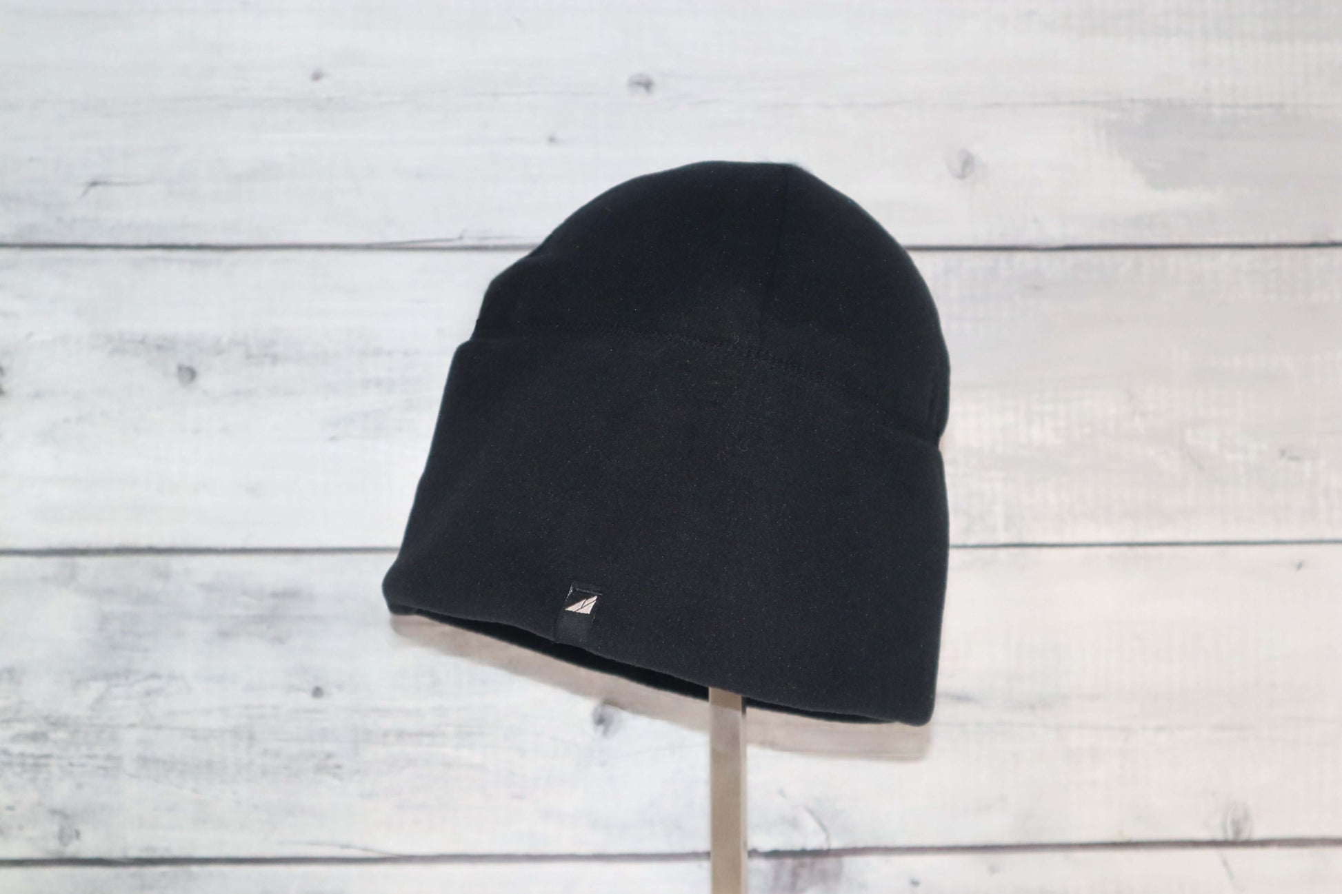 Adult Fleece Cap – Warm Stretch Beanie displayed on a stand with a black fleece material, perfect for cold weather.