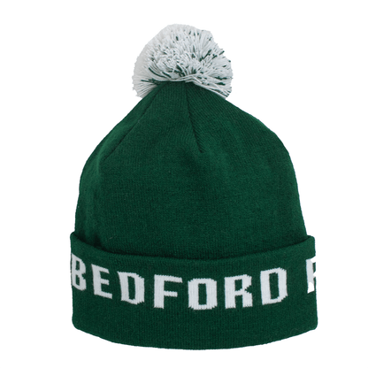 Adult Limited Edition Hat – Bedford Falls Beanie in green featuring a pom-pom and Bedford Falls designs.