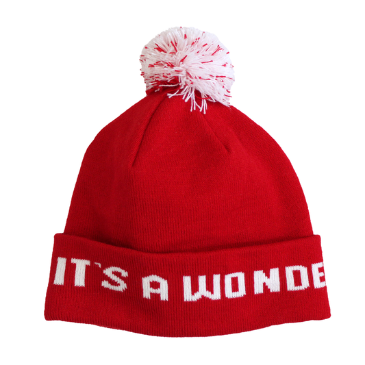 Adult Limited Edition Hat – Bedford Falls Beanie in red with a pom-pom and 'IT'S A WONDER' lettering.