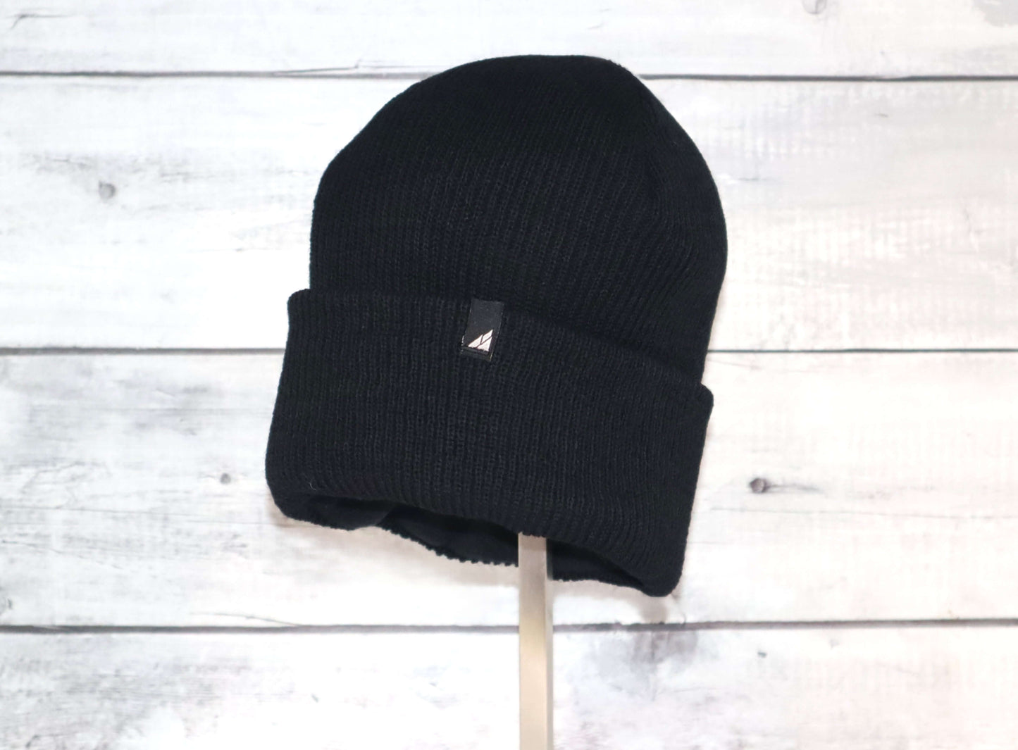 Adult Versatile Wool Watch Cap – Flexible Fit Winter Beanie in black on a wooden background.