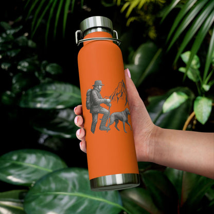 Personalized insulated hiking bottle with a mountain design held by a person in a lush green setting.