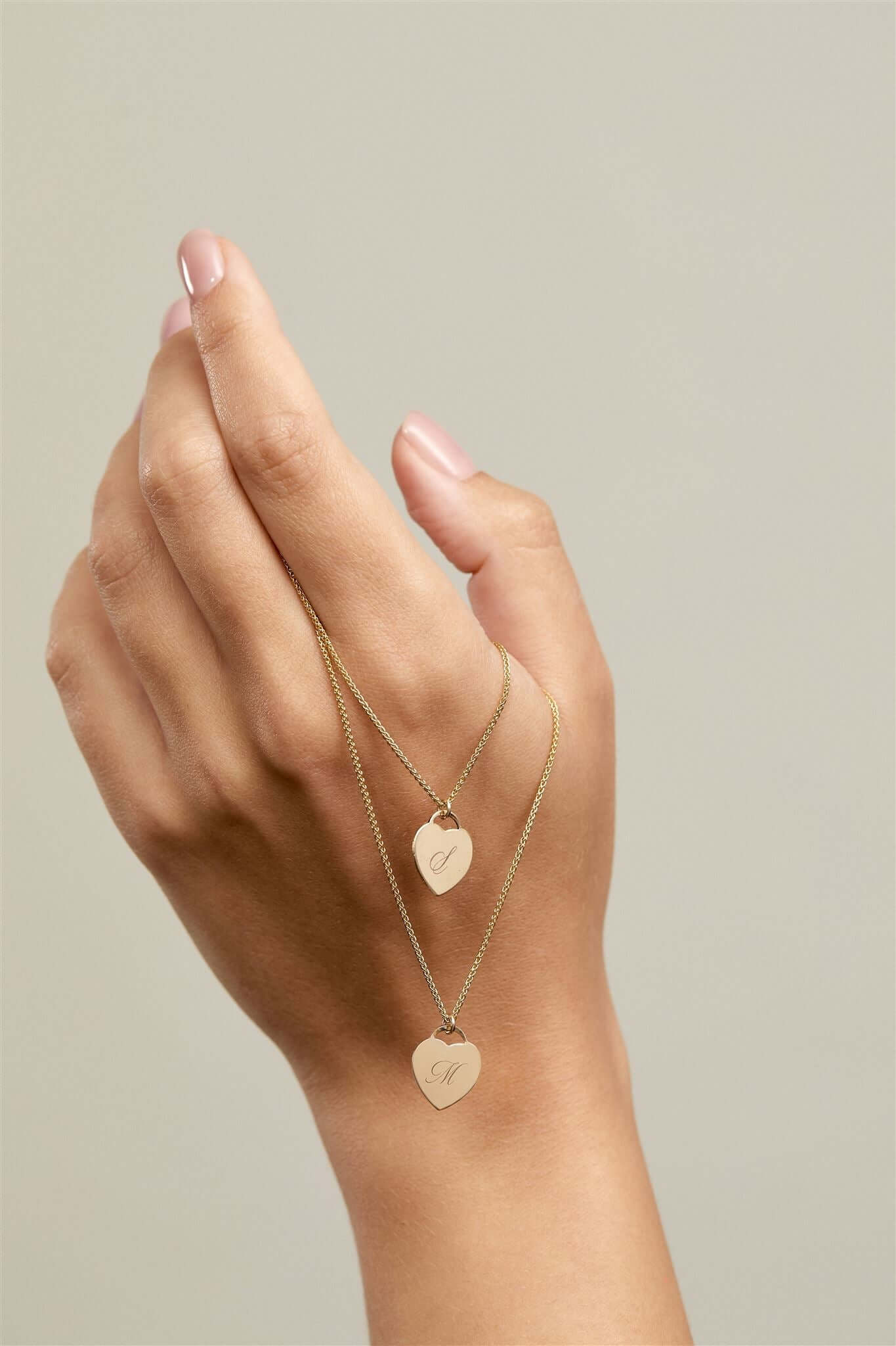 Alice Initial Necklace – Personalized 14k Gold-Filled Heart displayed elegantly on a hand with two heart charms.