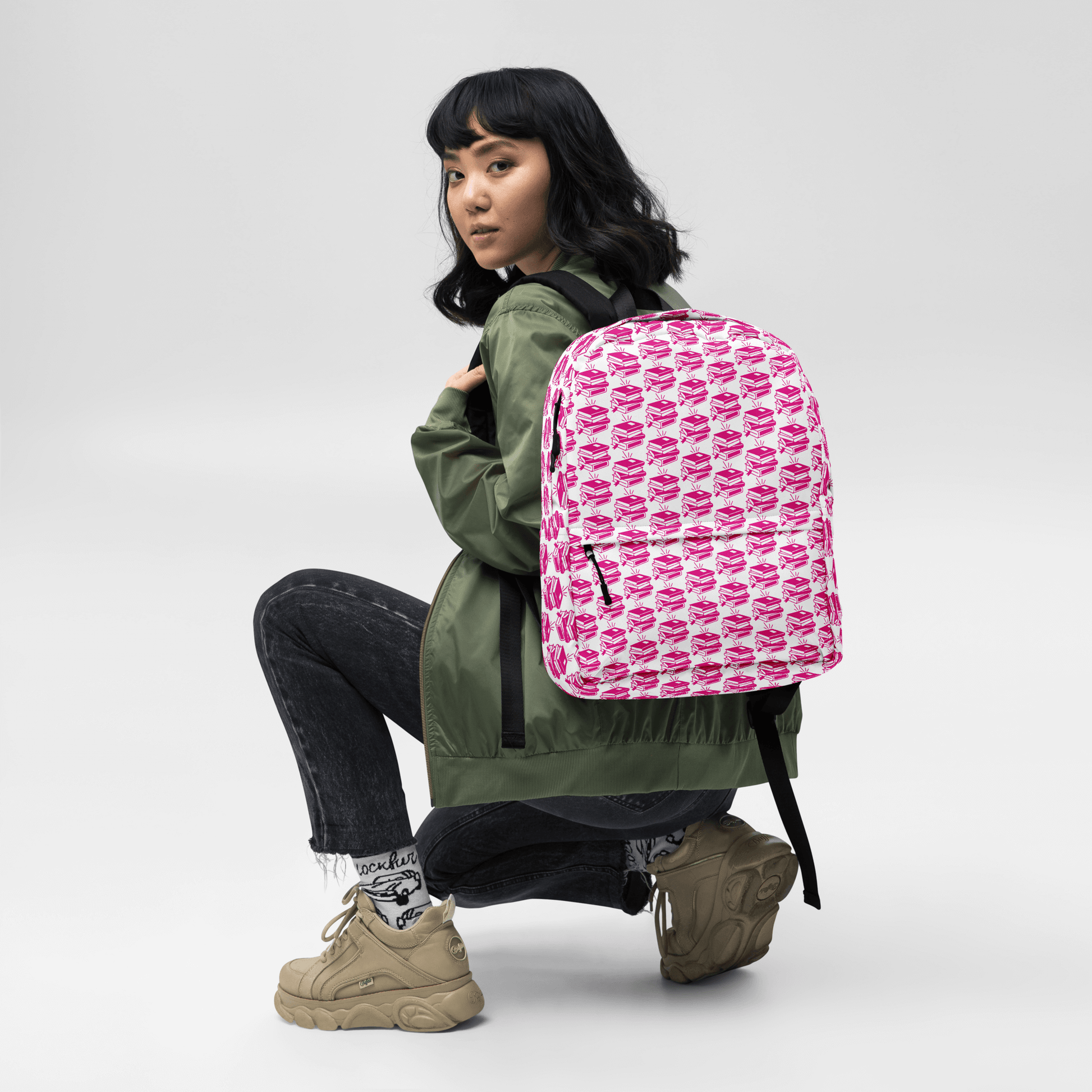 Model wearing a stylish Pack & Play Backpack in playful pink pattern, showcasing its sporty design and ergonomic features.