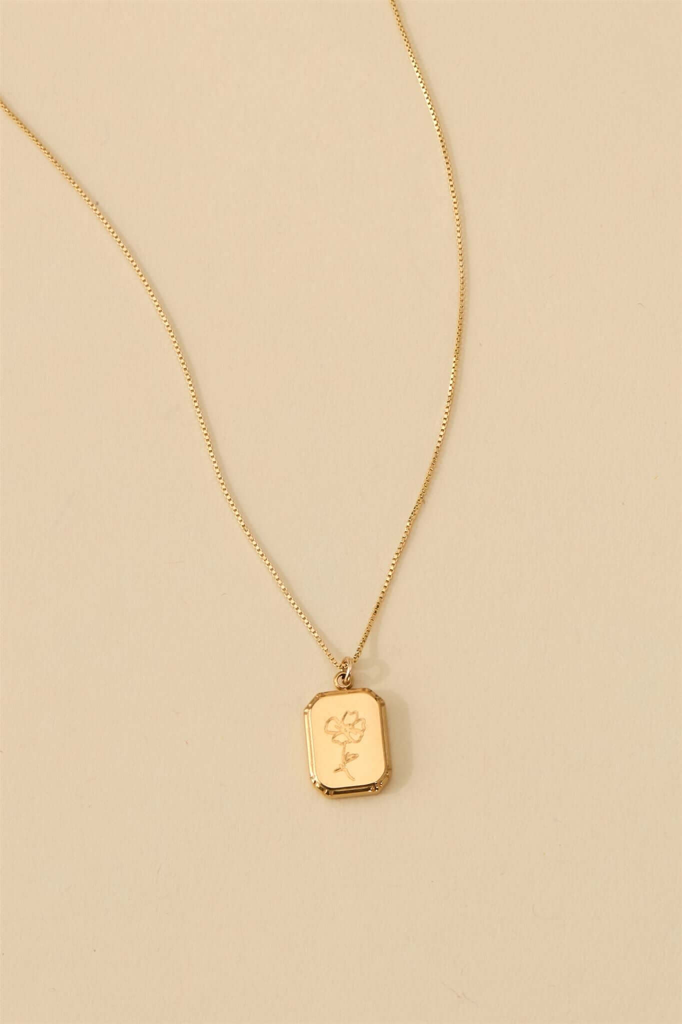 Audrey Birth Flower Necklace – Engraved 18k Gold Over Brass featuring a delicate flower pendant on a chain.