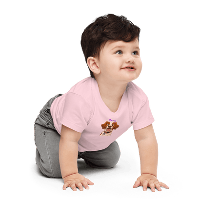 Baby wearing pink tee featuring custom cartoon dog design, smiling while crawling.