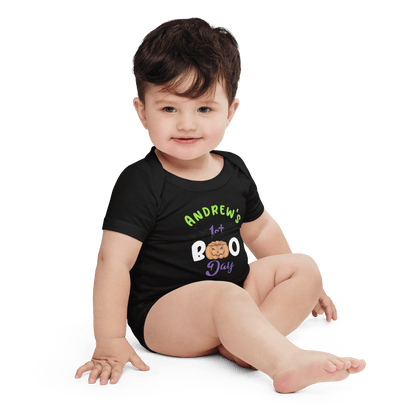 Baby wearing a personalized black Halloween bodysuit with 'Andrew's 1st Boo Day' text and playful pumpkin design.