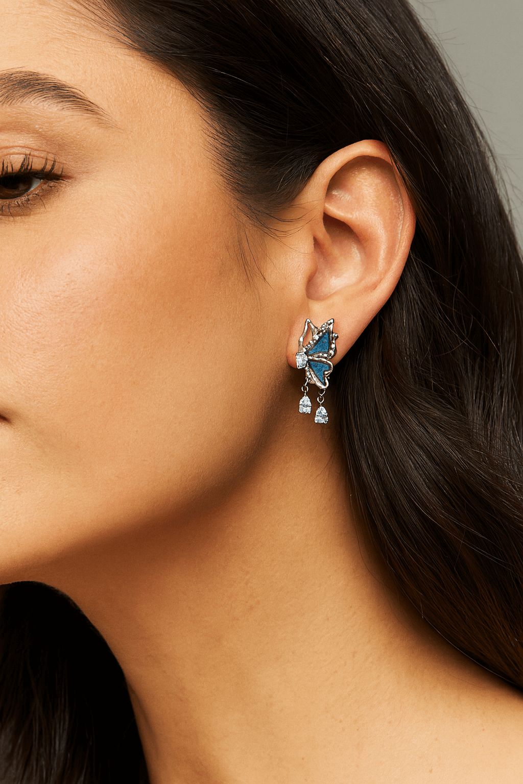 Blue Denim Butterfly Drop Earrings with Crystal Teardrop Sparkle worn by a model, showcasing their elegant design.