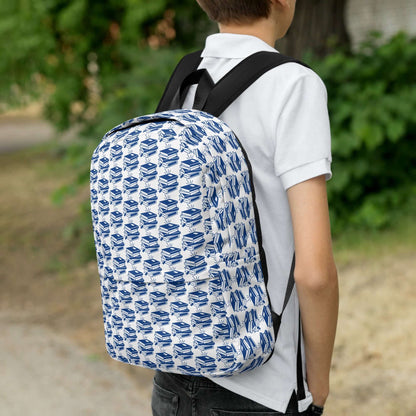 Youth carrying The Bookish Backpack with a blue geometric book pattern in an outdoor setting.