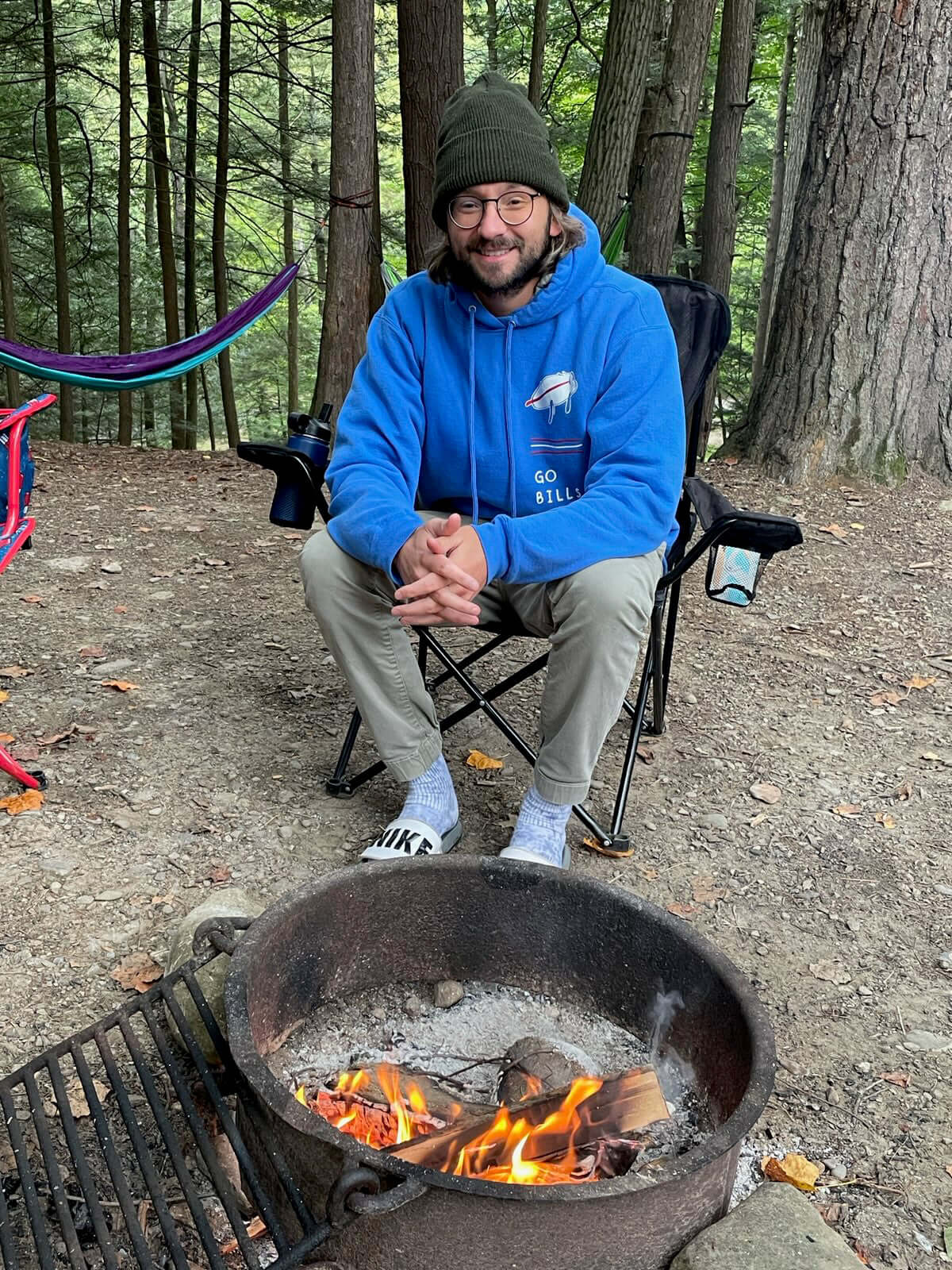Adult Versatile Wool Watch Cap – Flexible Fit Winter Beanie worn by a camper relaxing by a fire in the woods.
