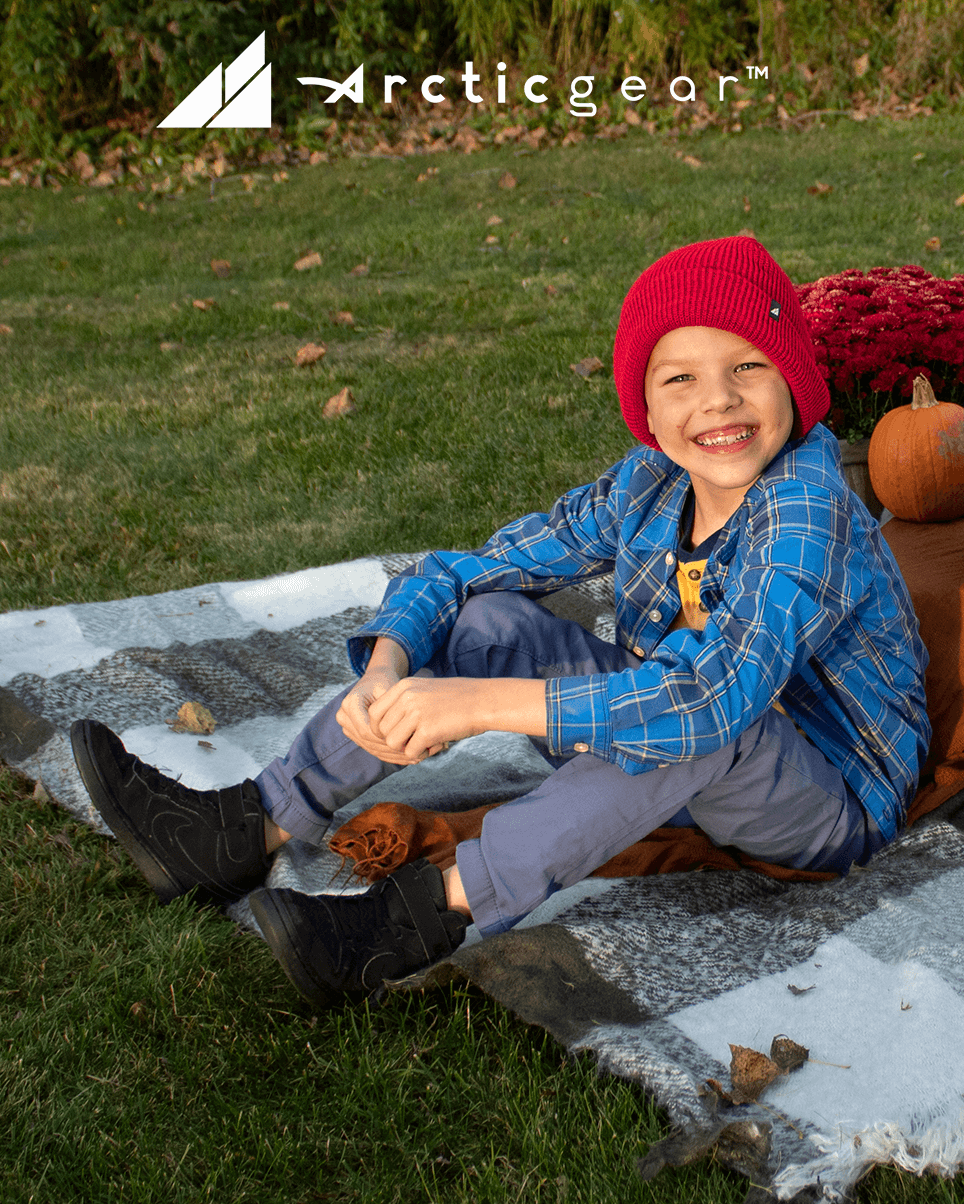 Child Acrylic Cuff Hat – Soft Knit Beanie for Kids worn by a smiling boy sitting on a blanket outdoors.