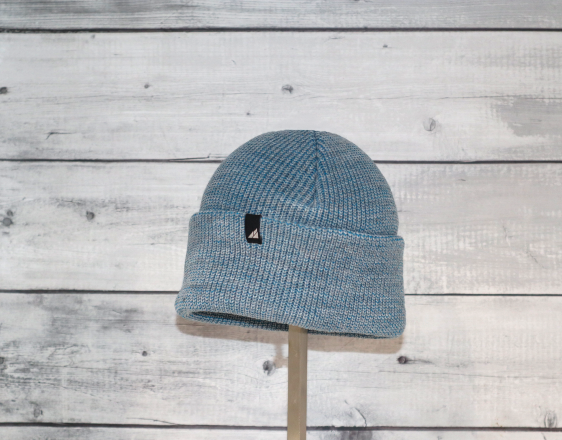 Child Acrylic Cuff Hat – Soft Knit Beanie for Kids displayed on a stand against a wood backdrop.
