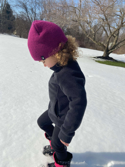 Child Acrylic Cuff Hat – Soft Knit Beanie for Kids worn by a child playing in the snow.