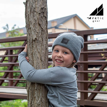 Child Acrylic Wool Beanie – Soft Winter Hat for Kids worn by a happy child playing outdoors.