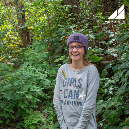 Child Acrylic Wool Beanie – Soft Winter Hat for Kids worn by a girl in a green forest setting.