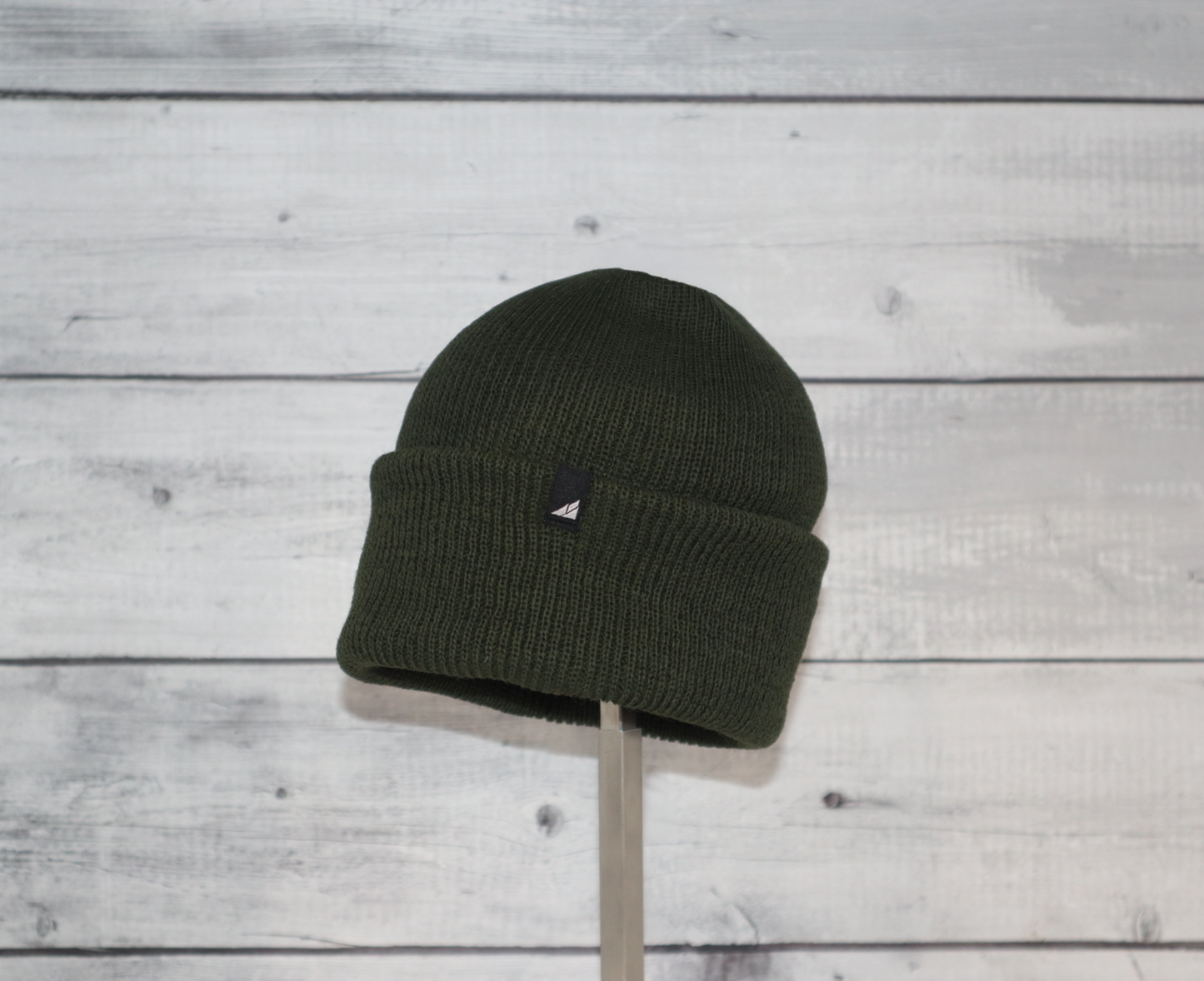Child Versatile Wool Watch Cap – Arctic Gear Beanie in dark green displayed on a stand.