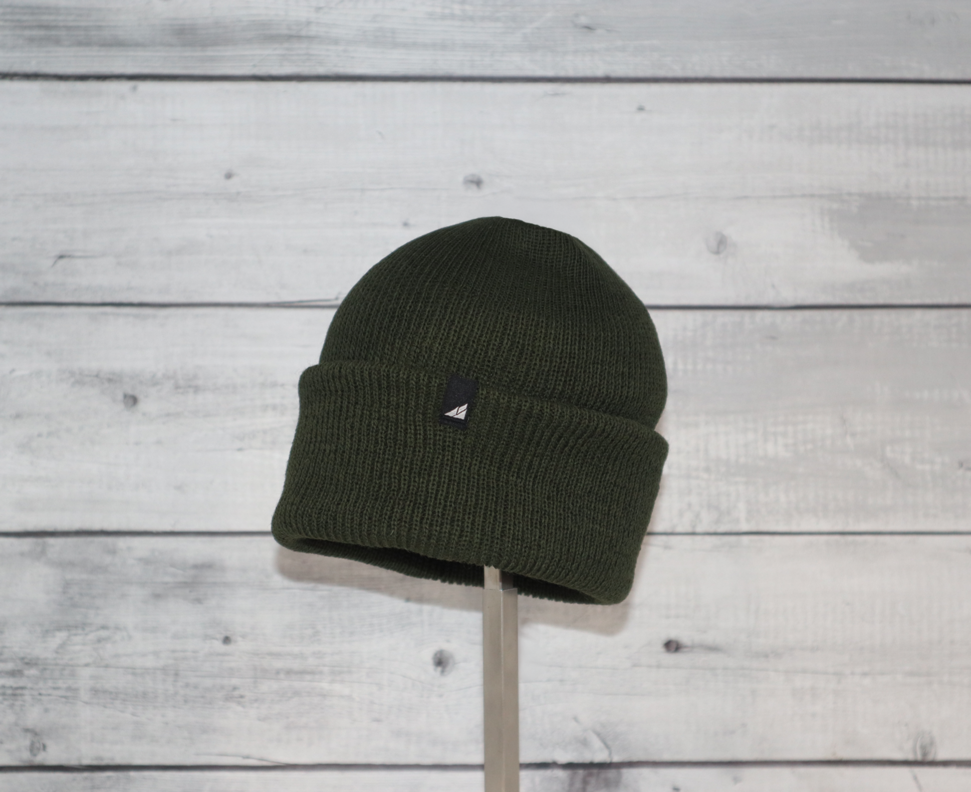 Child Versatile Wool Watch Cap – Arctic Gear Beanie in dark green displayed on a stand.