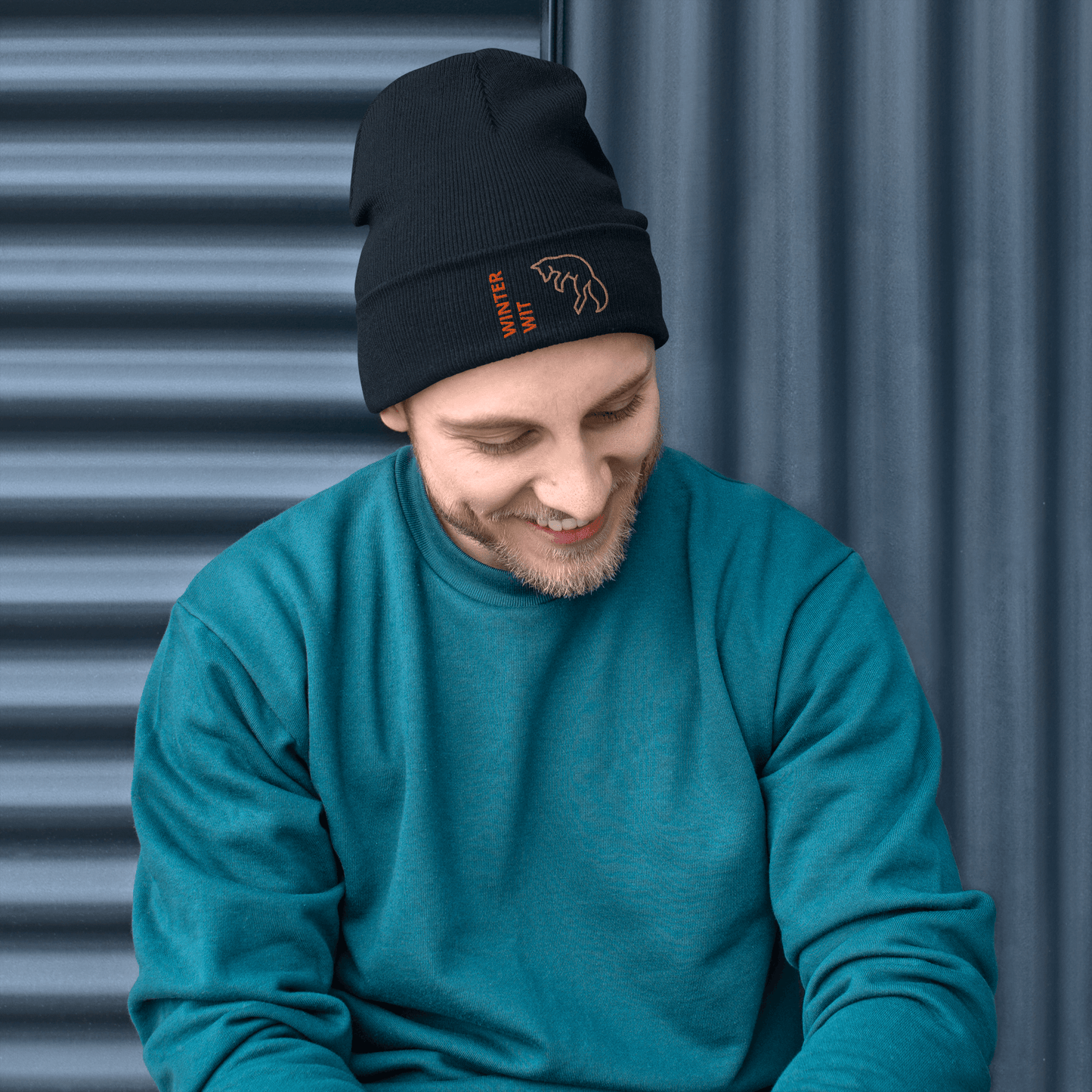 Man wearing a stylish Fox Beanie – Embroidered Knit Hat with Custom Text, smiling against a textured background.