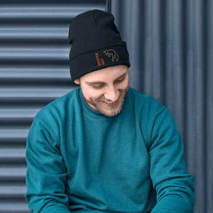 Man wearing a stylish Fox Beanie – Embroidered Knit Hat with Custom Text, smiling against a textured background.