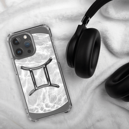 Zodiac Gemini Magsafe clear iPhone case with metallic design on a cozy surface next to headphones.