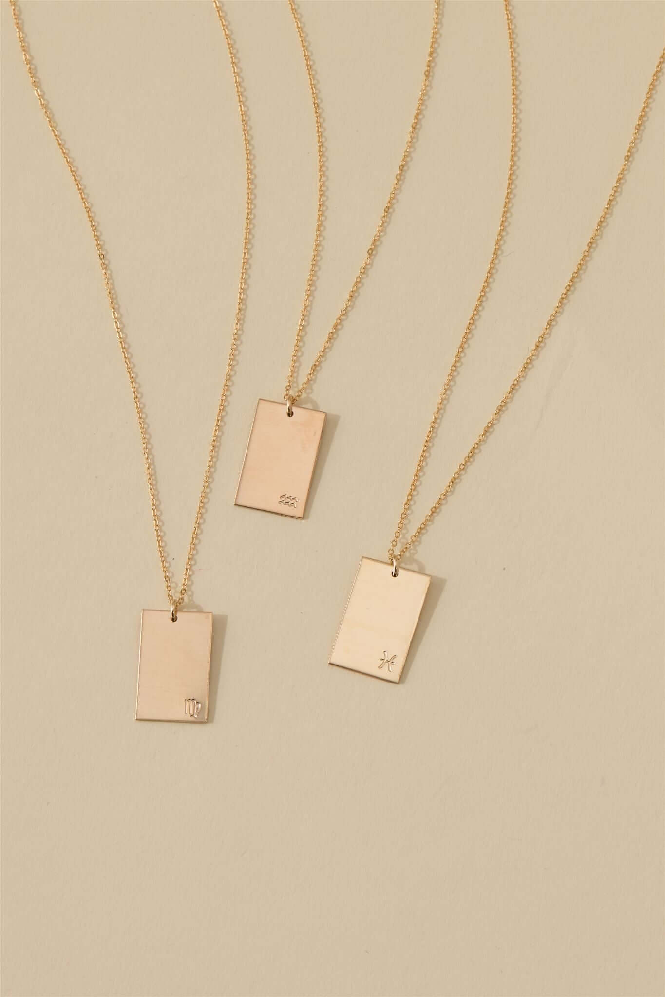 Goldie Horoscope Necklace – Hand-Stamped Zodiac in Gold-Filled displayed with multiple gold-filled pendants on a neutral background.