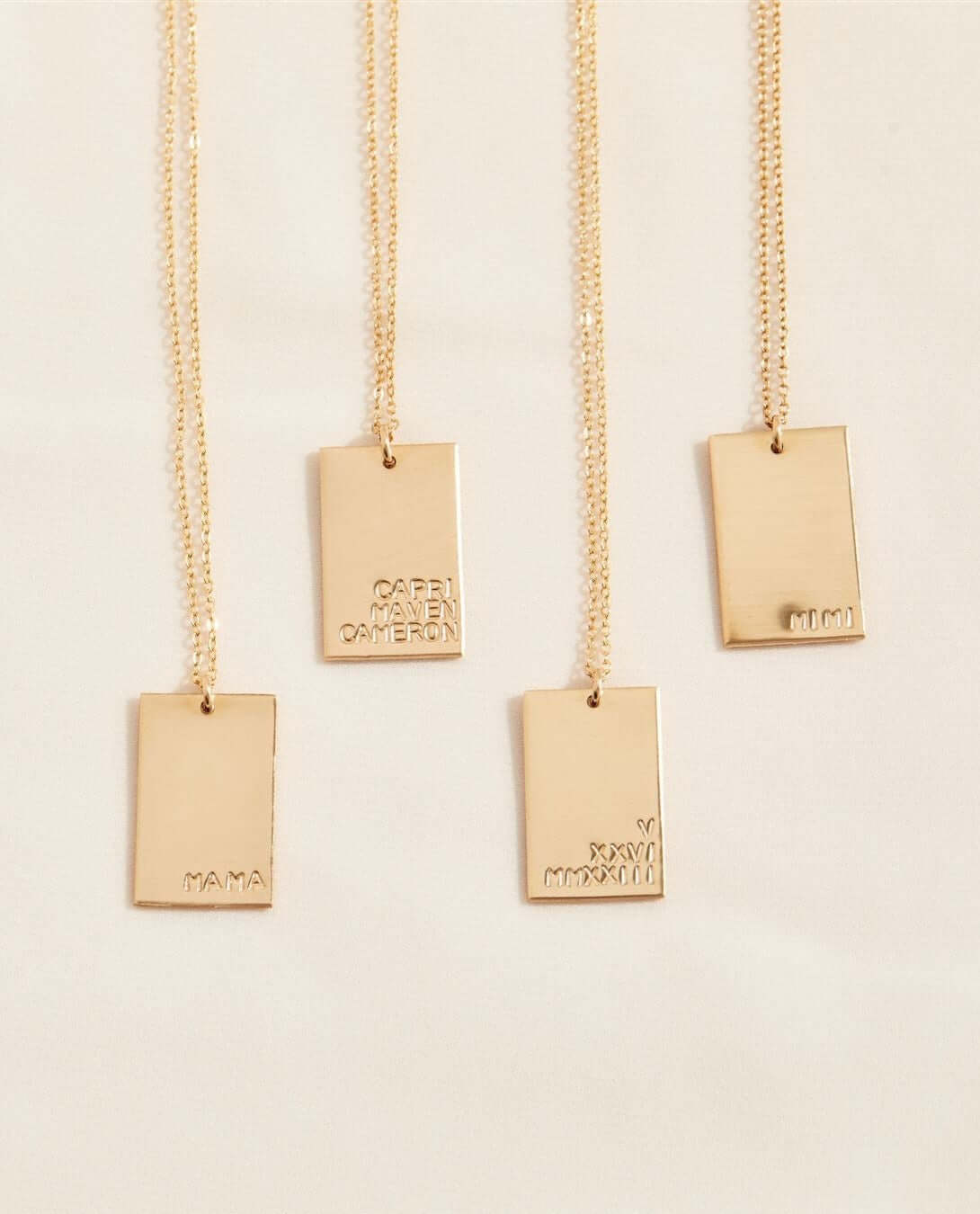 Goldie MAMA Necklace – Hand-Stamped 14k Gold-Filled Pendant showcasing four gold necklaces with engraved pendants.