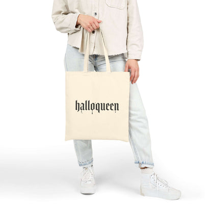 Person holding a light tote bag with the text 'halloqueen' in bold lettering, perfect for Halloween vibes.
