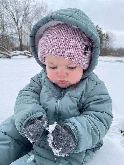 Infant Acrylic Cuff Hat – Soft Knit Beanie for Ages 3–12M worn by a baby playing in the snow, dressed in a warm winter suit.