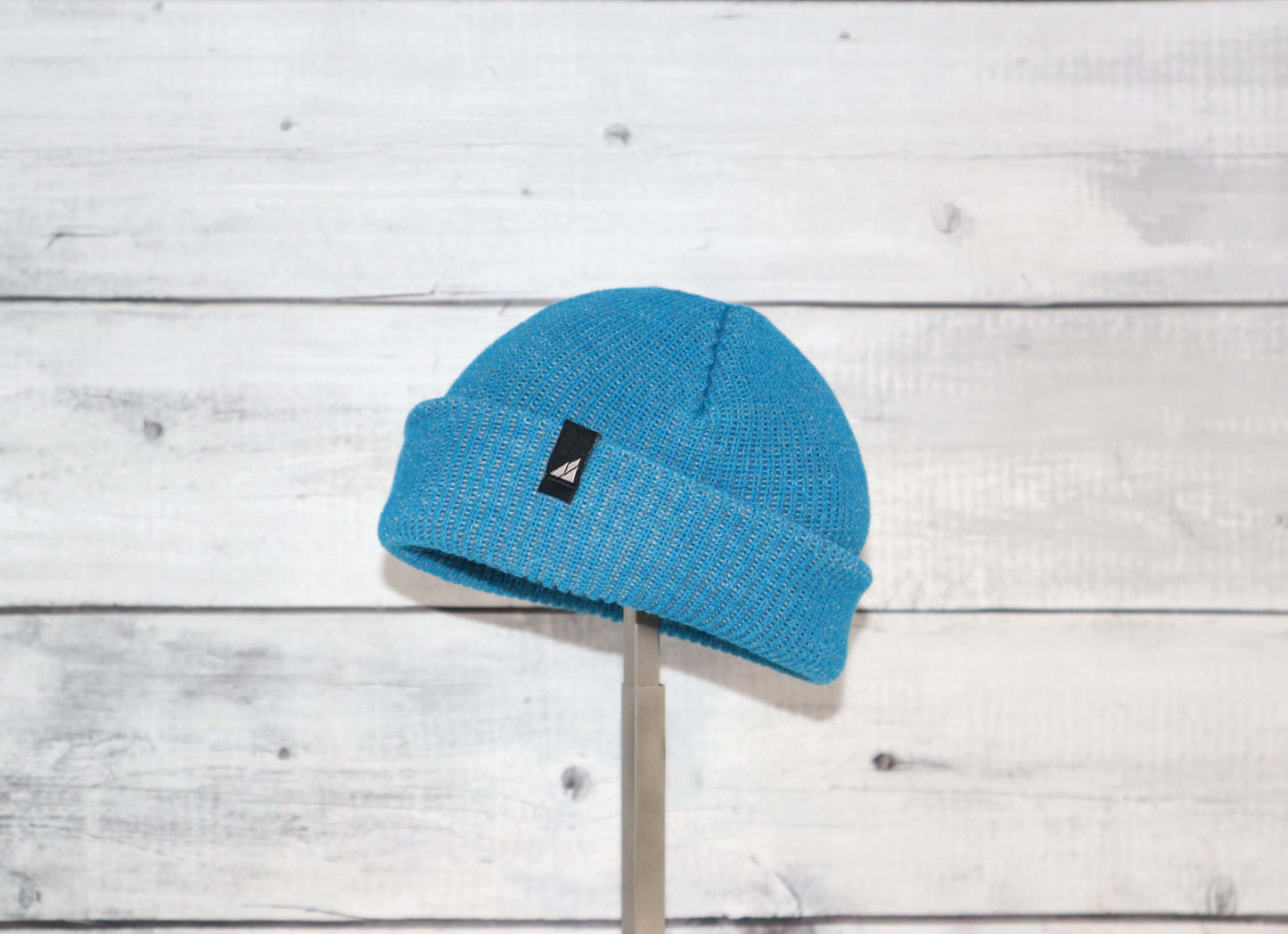 Infant Acrylic Cuff Hat – Soft Knit Beanie for Ages 3–12M in blue on a wooden background.