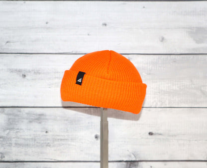 Infant Acrylic Cuff Hat – Soft Knit Beanie for Ages 3–12M in bright orange color displayed on a wooden background.