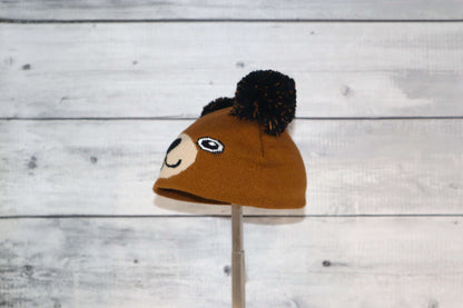 Infant Specialty Hat – Cozy, Playful, Purposeful featuring a cute bear design with pom poms.