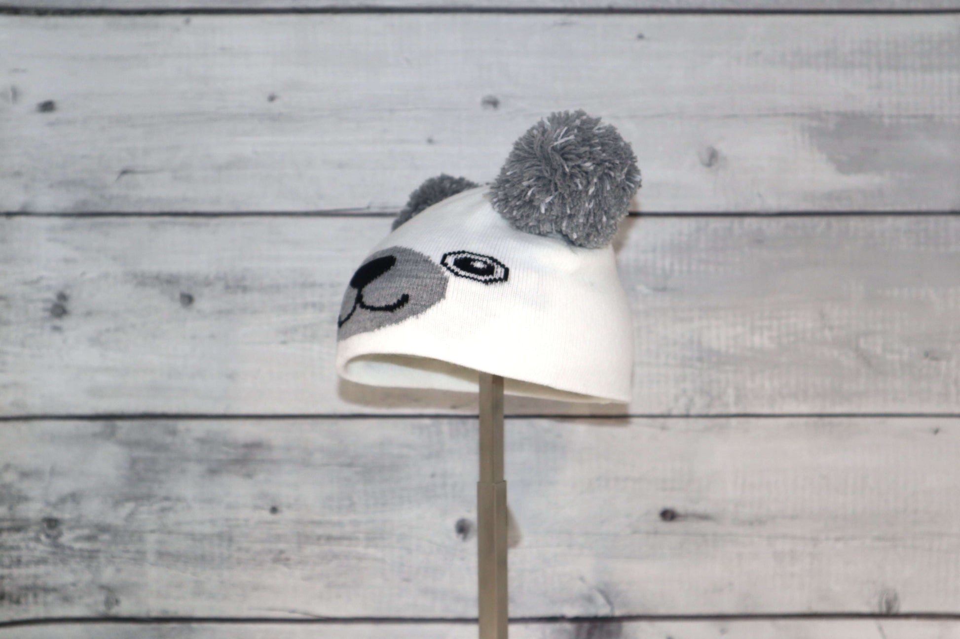 Infant Specialty Hat – Cozy, Playful, Purposeful featuring a cute animal design with grey ears and pom poms.