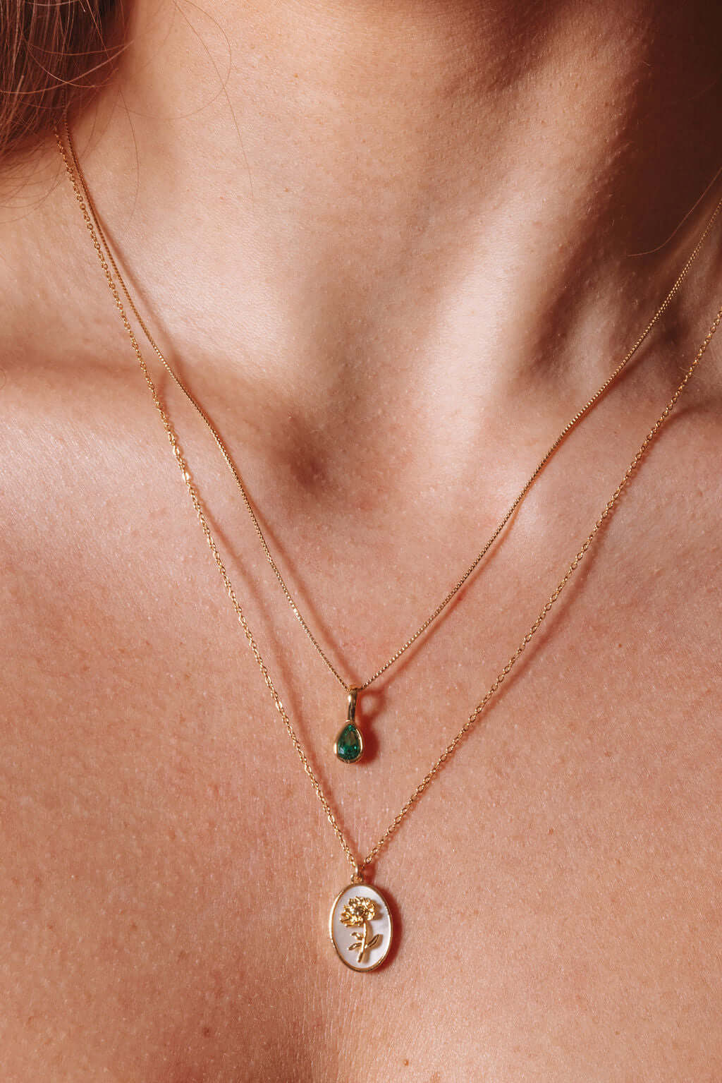 Katrina Birth Flower Necklace – Gold-Filled & Mother of Pearl on display, featuring gold chains and a green gemstone pendant.