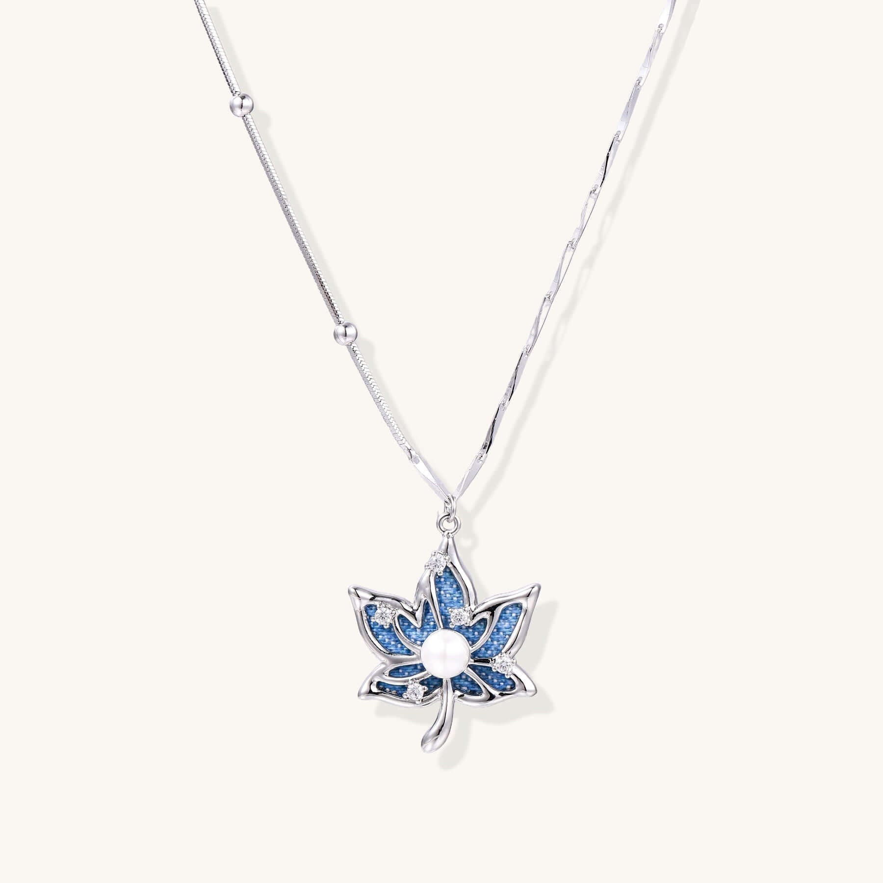 Lotus Dreams Necklace – Blue Crystal Pendant on Gold-Plated Chain, featuring blue pavé petals and a pearl center.