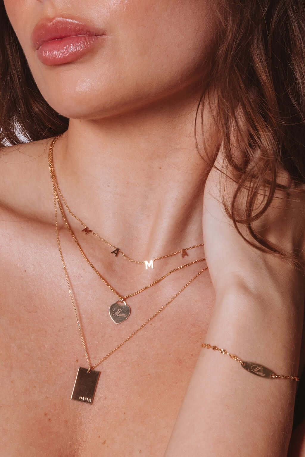Mama Alice Necklace – 14k Gold-Filled Heart on Wheat Chain worn elegantly with other gold necklaces.