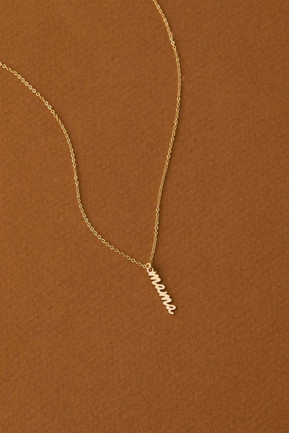 Mama Charm Necklace – 14k Gold-Filled Chain & Pendant on a warm brown background, highlighting its elegant design.