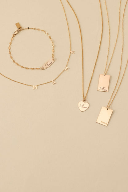 Mama Stella Necklace – 14k Gold-Filled Hand-Engraved Pendant displayed with other gold jewelry.