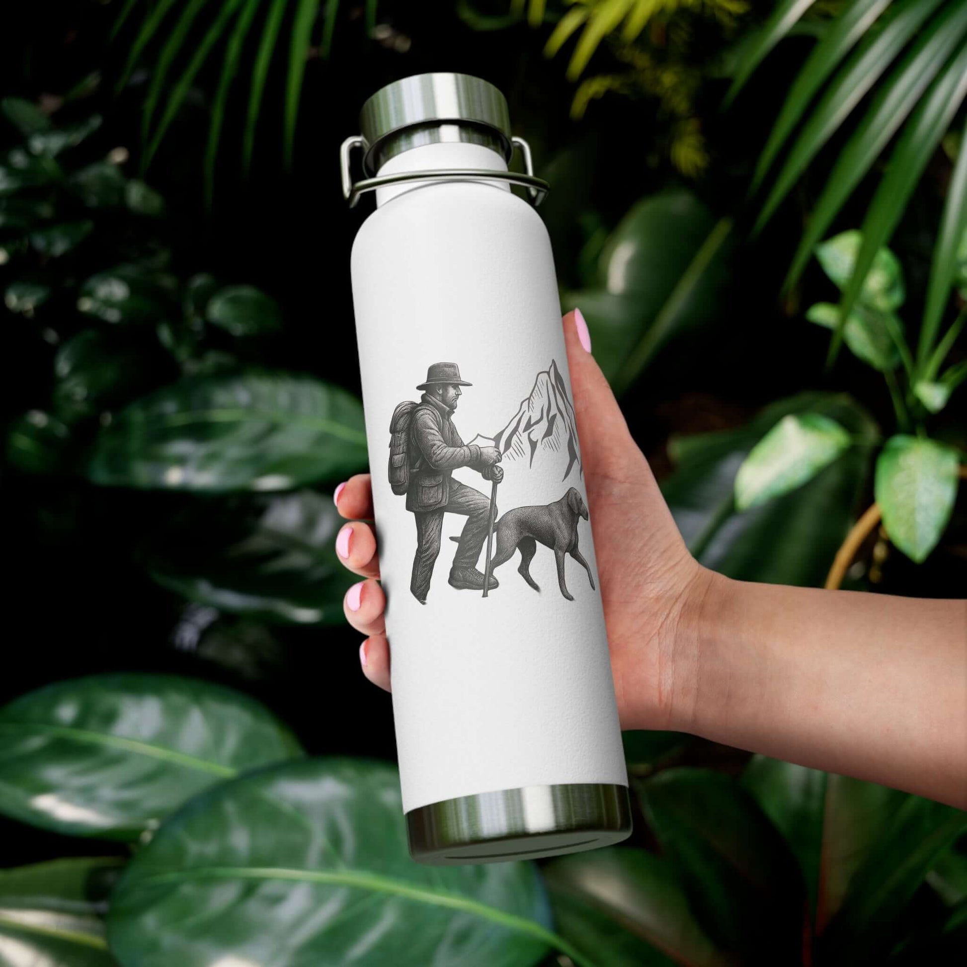 Personalized hiking bottle held by a person with a design of a hiker and dog against lush green foliage.