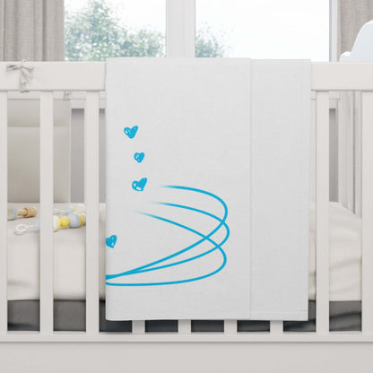 Personalized baby blanket with blue heart design draped over a crib for cozy nursery decor.
