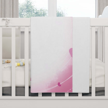 Personalized baby blanket with pink heart-themed design draped over a crib, perfect for nursery decor.