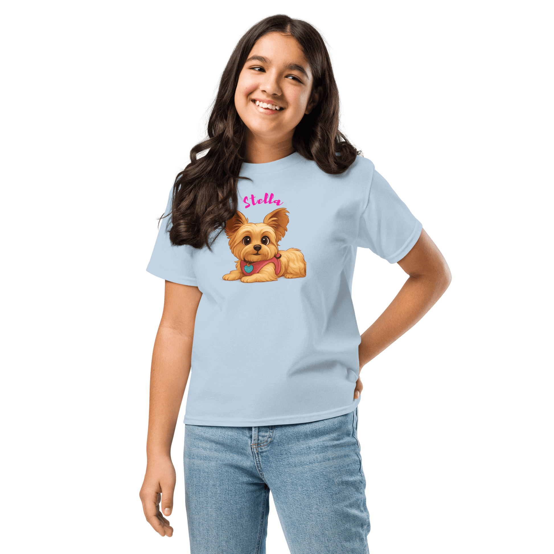 Smiling girl wearing a light blue shirt with a cartoon dog illustration and the name 'Stella' printed on it.