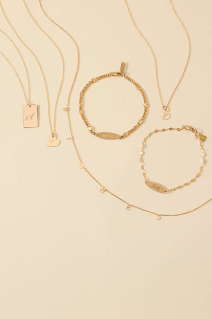 The First Layer – Personalized Sophia Initial Necklace in 14k Gold-Filled displayed with matching gold jewelry.