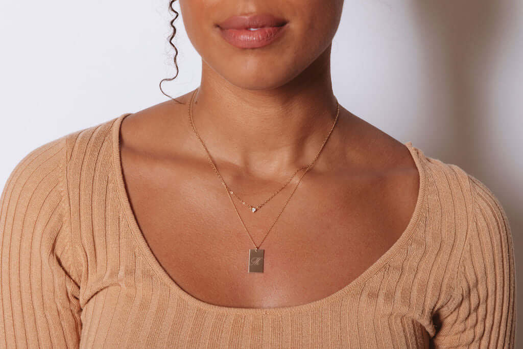 Stella Gold Initial Necklace – Personalized 14k Gold-Filled Pendant worn by a model, showcasing its delicate design.