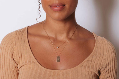 Stella Gold Initial Necklace – Personalized 14k Gold-Filled Pendant worn by a model, showcasing its delicate design.