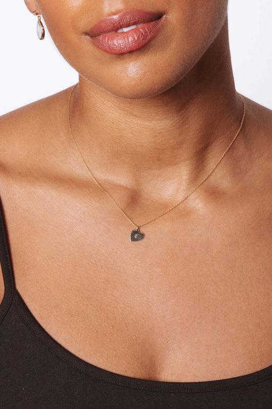 The First Layer – Personalized Sophia Initial Necklace in 14k Gold-Filled worn by a model, featuring a heart pendant.