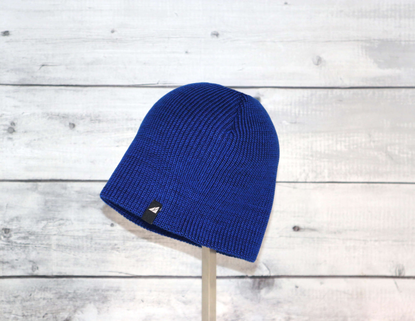 Toddler Acrylic Beanie – Soft Stretch Hat for Ages 1–3 in blue on a wooden background.