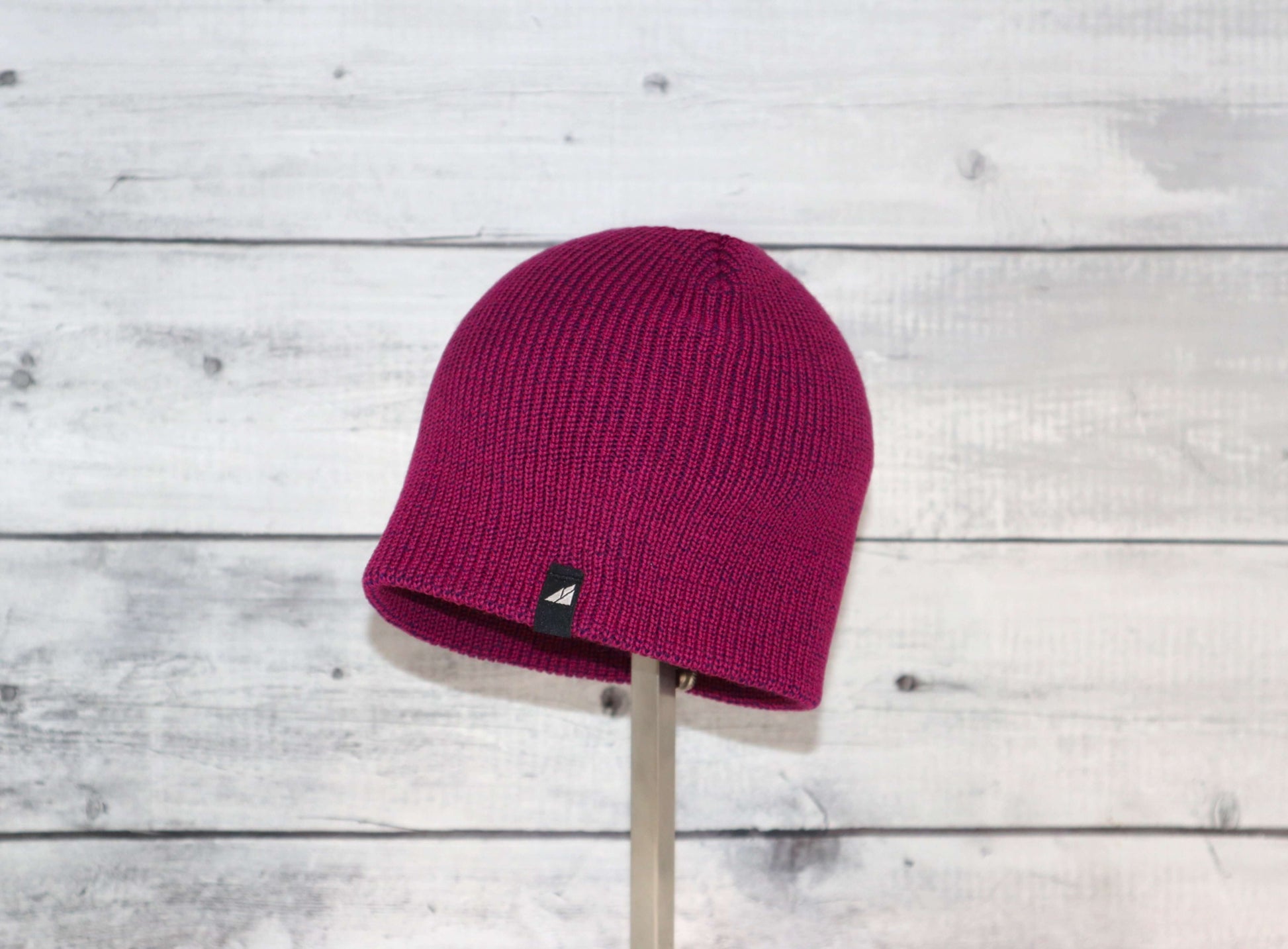 Toddler Acrylic Beanie – Soft Stretch Hat for Ages 1–3 in vibrant fuchsia color displayed on a wooden background.