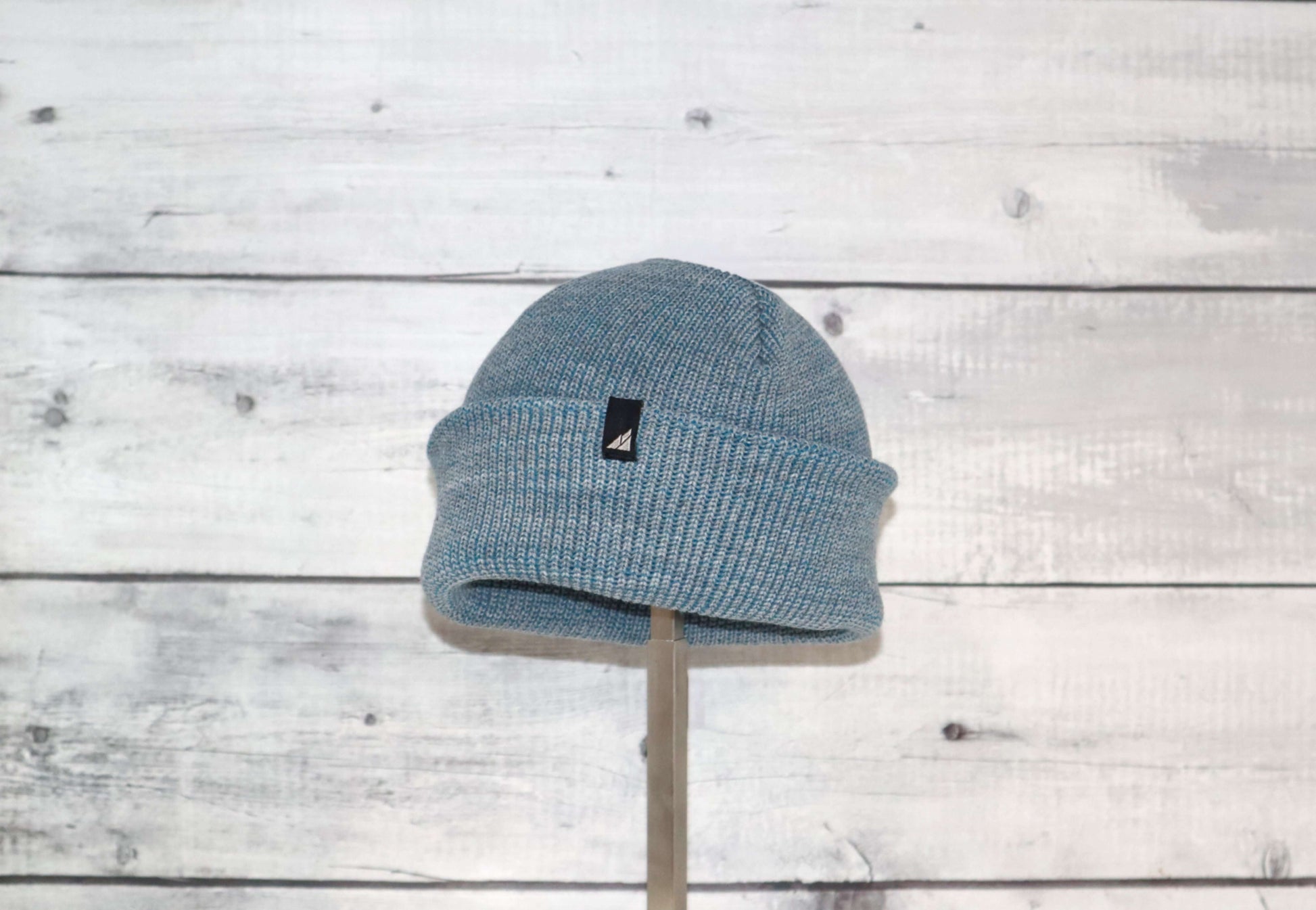 Toddler Acrylic Cuff Hat – Soft Knit Beanie displayed on a stand against a wood background.